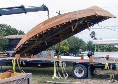 A crane lifts the hull off of the flatbed