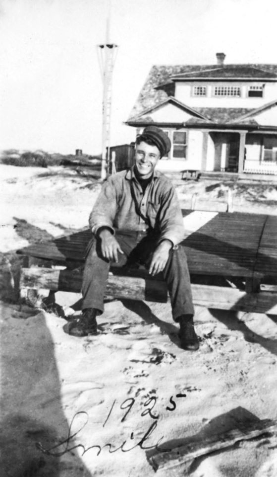 Man in uniform sitting on steps in front of the building.