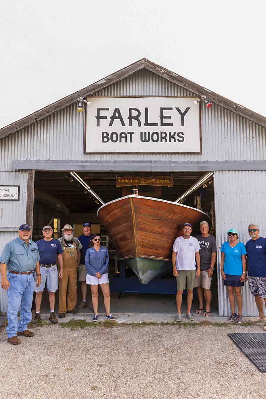 Charles Ferguson with several people in front of Farley Boat Works