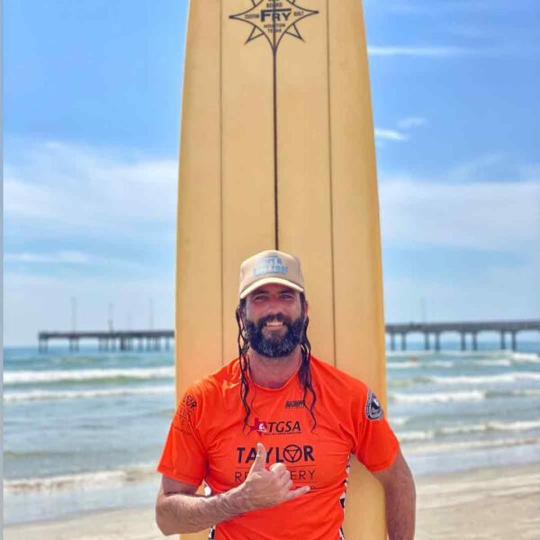 Man in orange shirt with surfboard