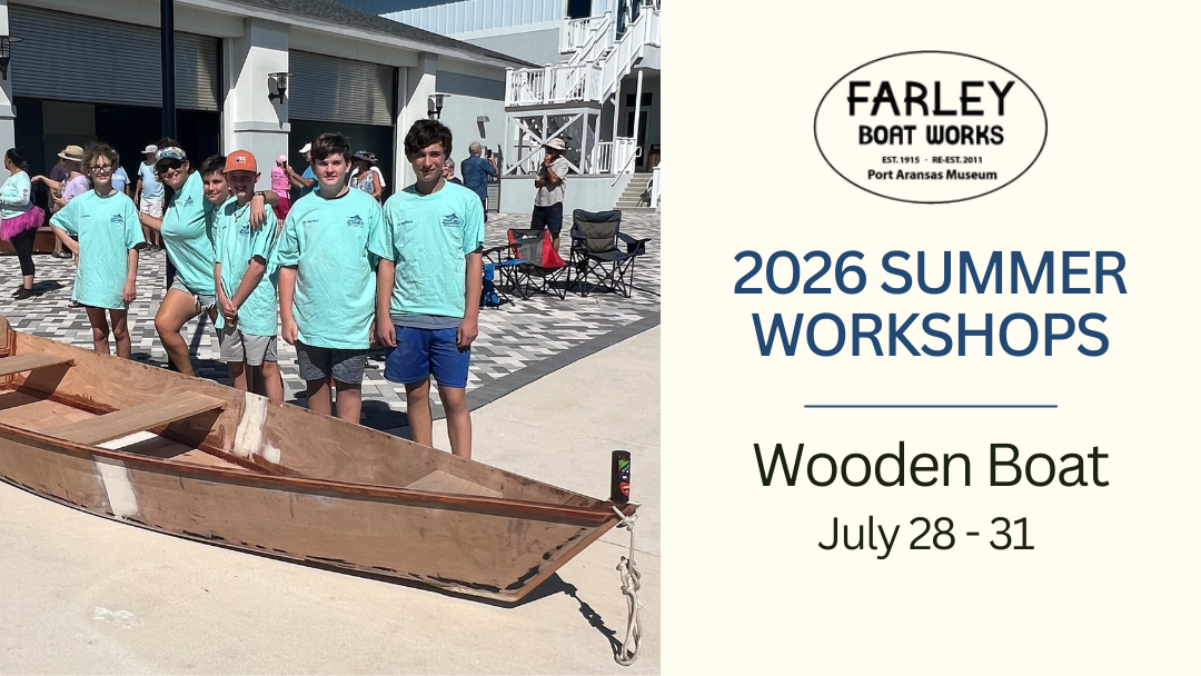 Several students standing near a boat they built